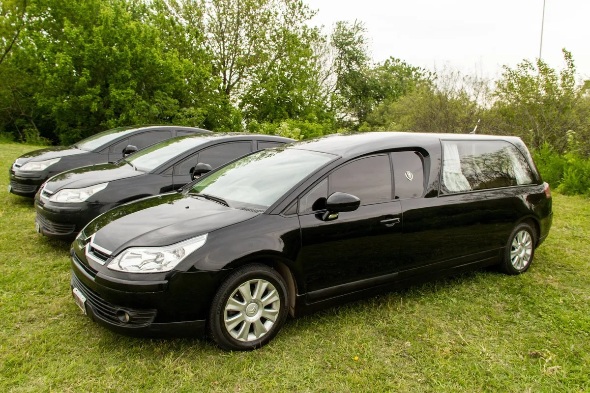 Coches fúnebres de la Cochería Mario Ratto en el jardín